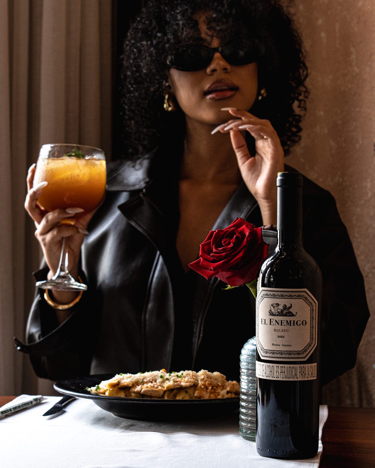 Retrato de mujer con chaqueta de cuero brindando en el salón del restaurante