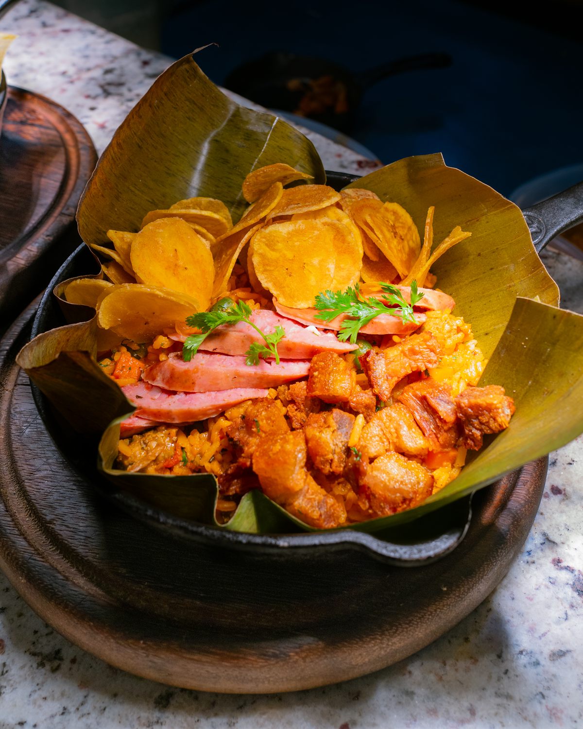 Cazuela de mariscos con chips de plátano y hojas de plátano