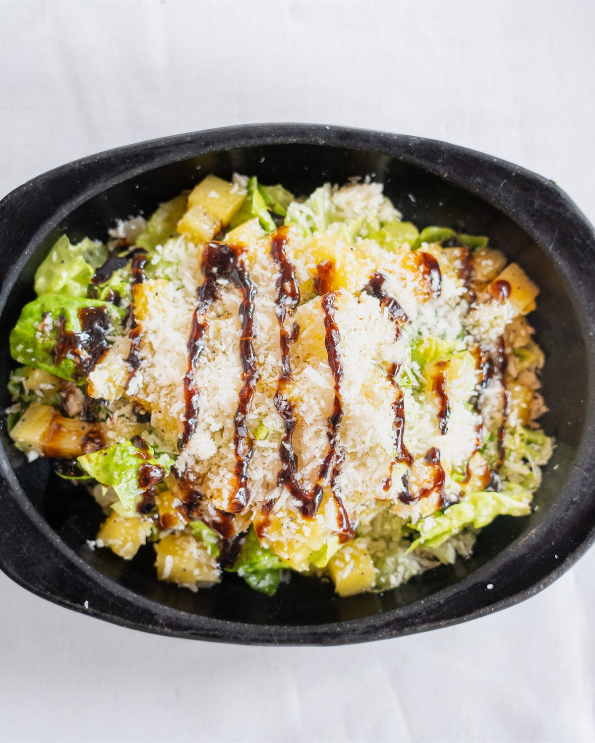 Plato de proteína con ensalada verde en recipiente de hierro