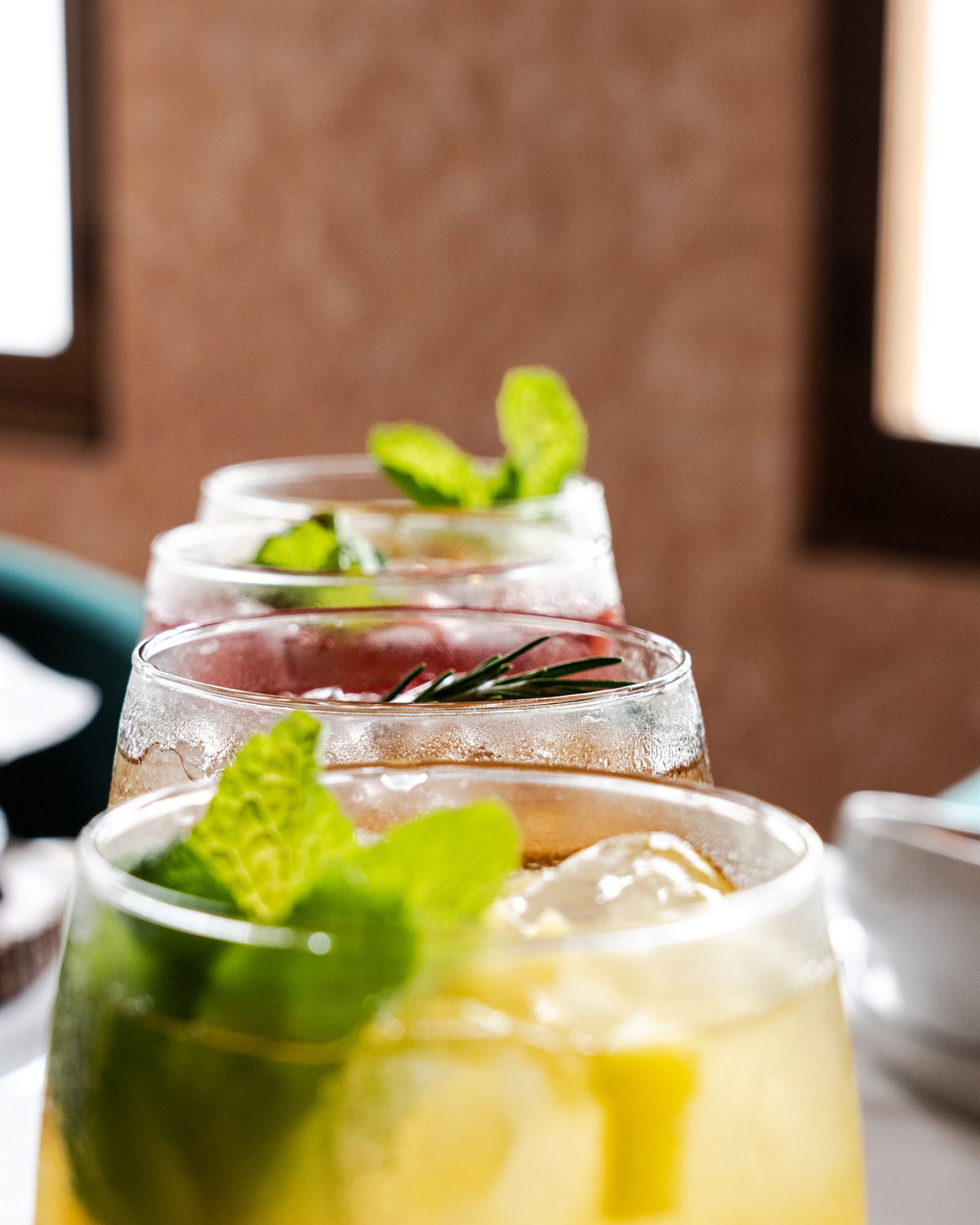 Cócteles con hierbabuena y hielo alineados sobre la barra
