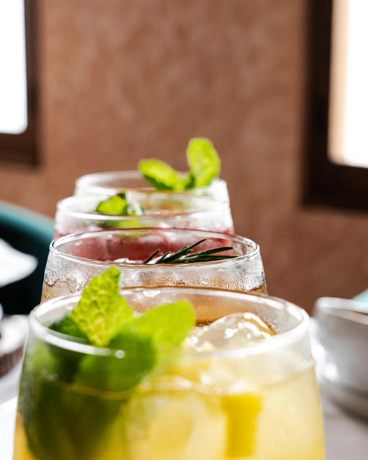 Cócteles con hierbabuena y hielo alineados sobre la barra
