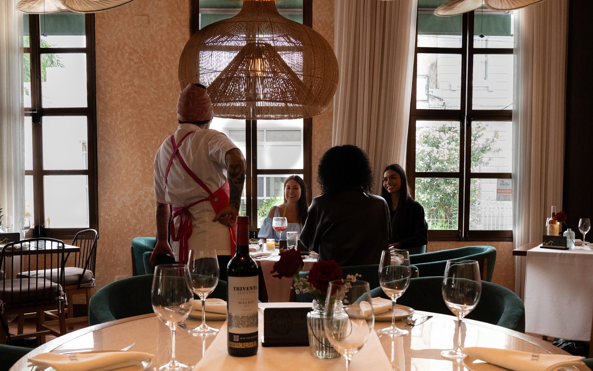 Salón del restaurante con lámparas de mimbre y mesas servidas