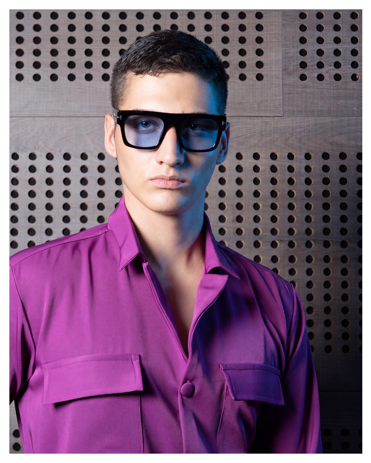 Modelo con camisa morada abierta y gafas oscuras