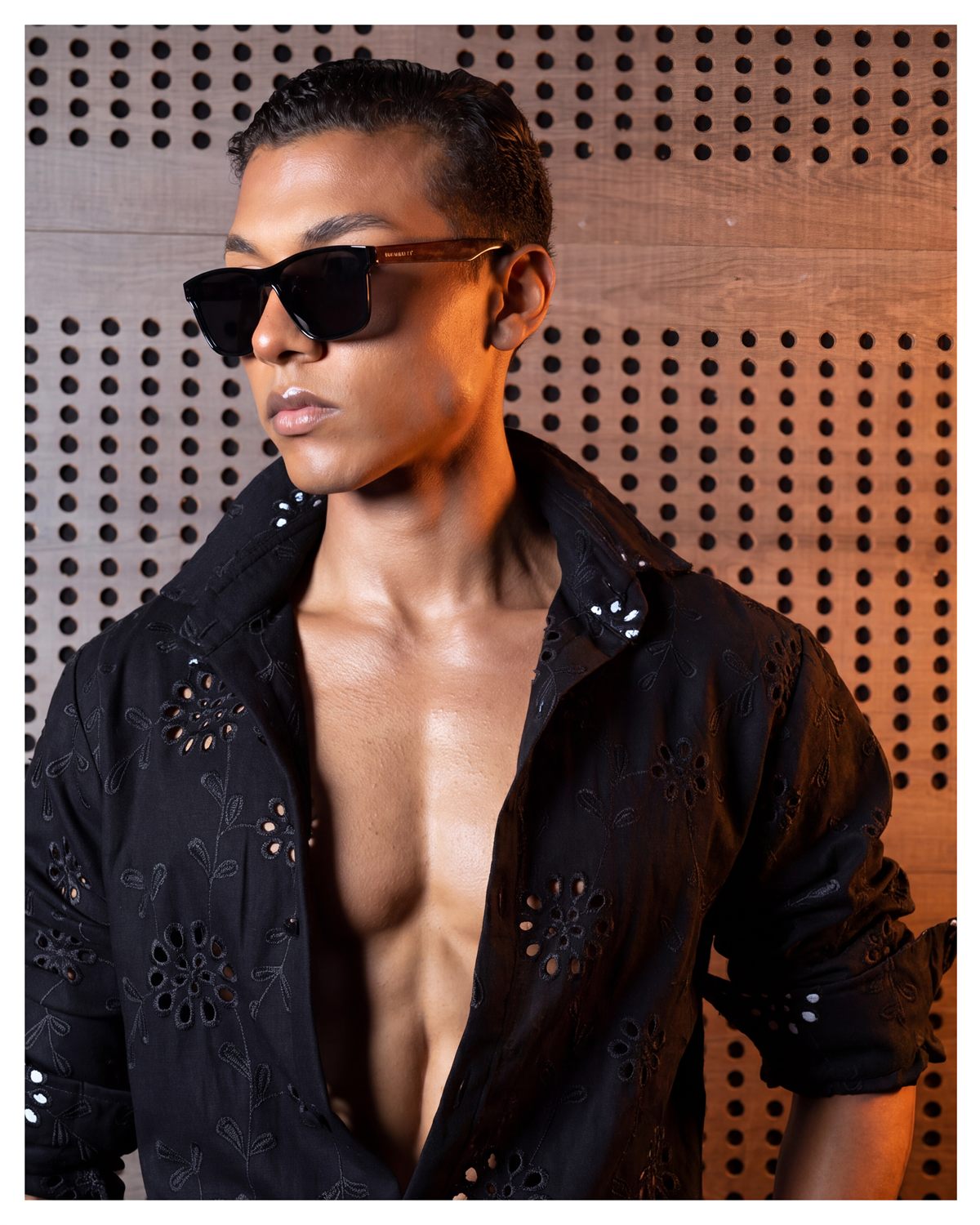 Modelo con camisa negra bordada y pantalón de vestir