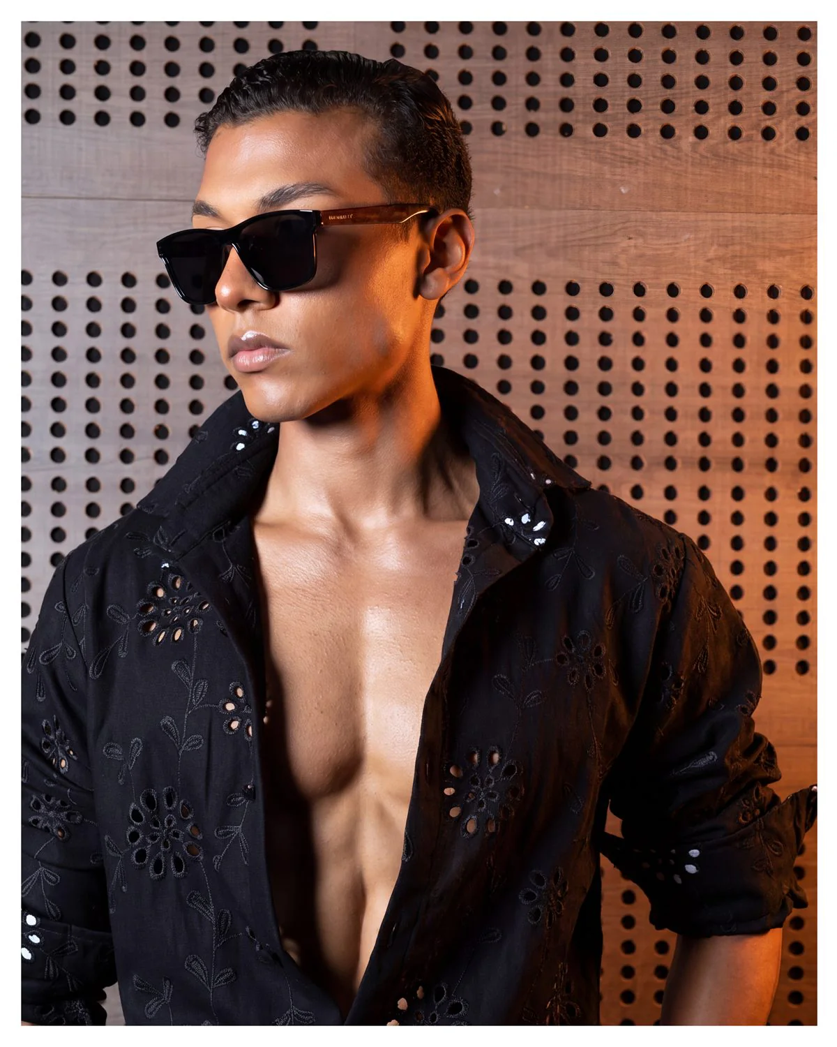 Modelo con camisa negra bordada y pantalón de vestir