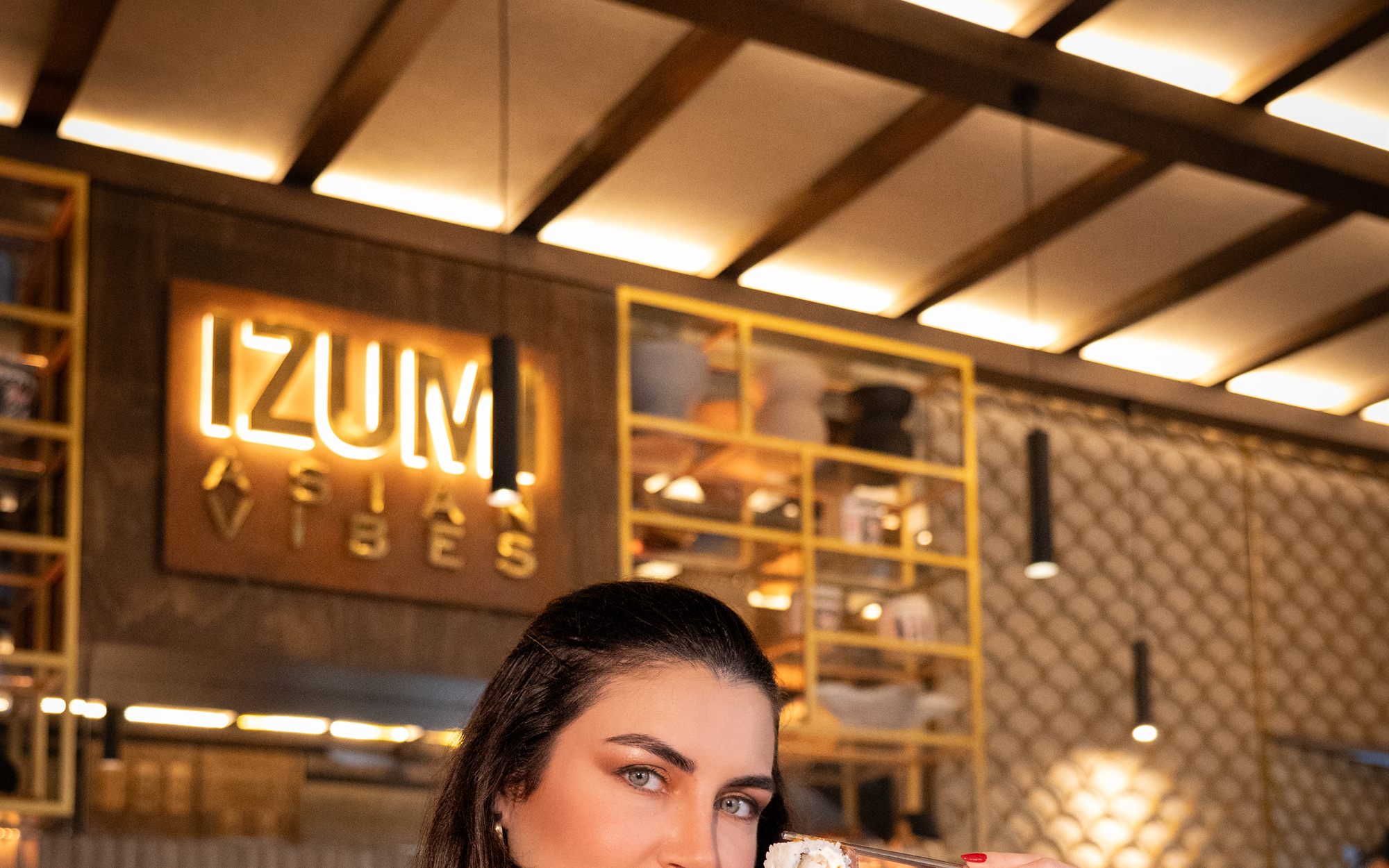 Salón del restaurante con el letrero luminoso IZUMI al fondo