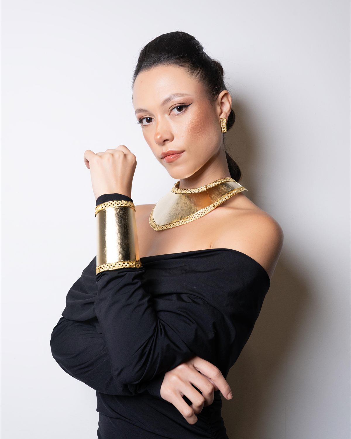 Brazalete ancho de latón dorado y gargantilla sobre manga negra