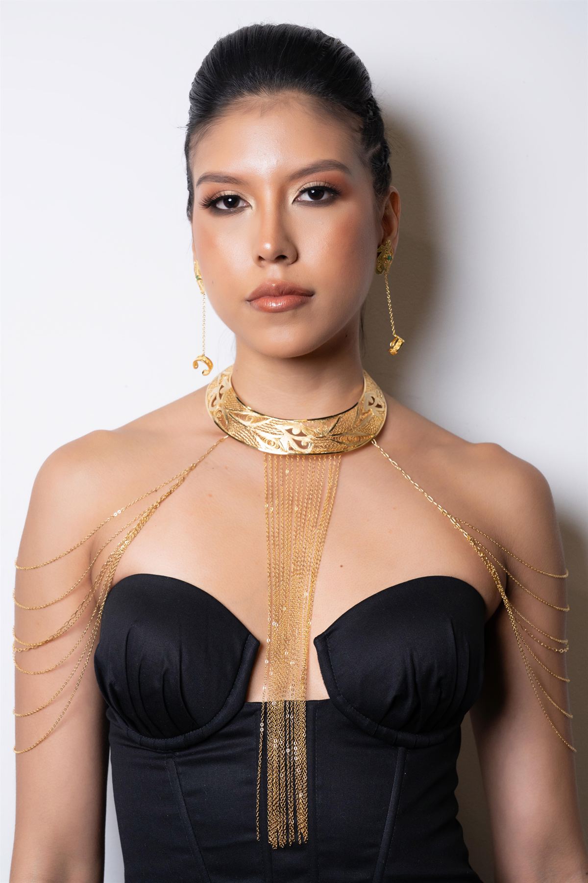 Modelo con collar de filigrana dorada y aretes a juego