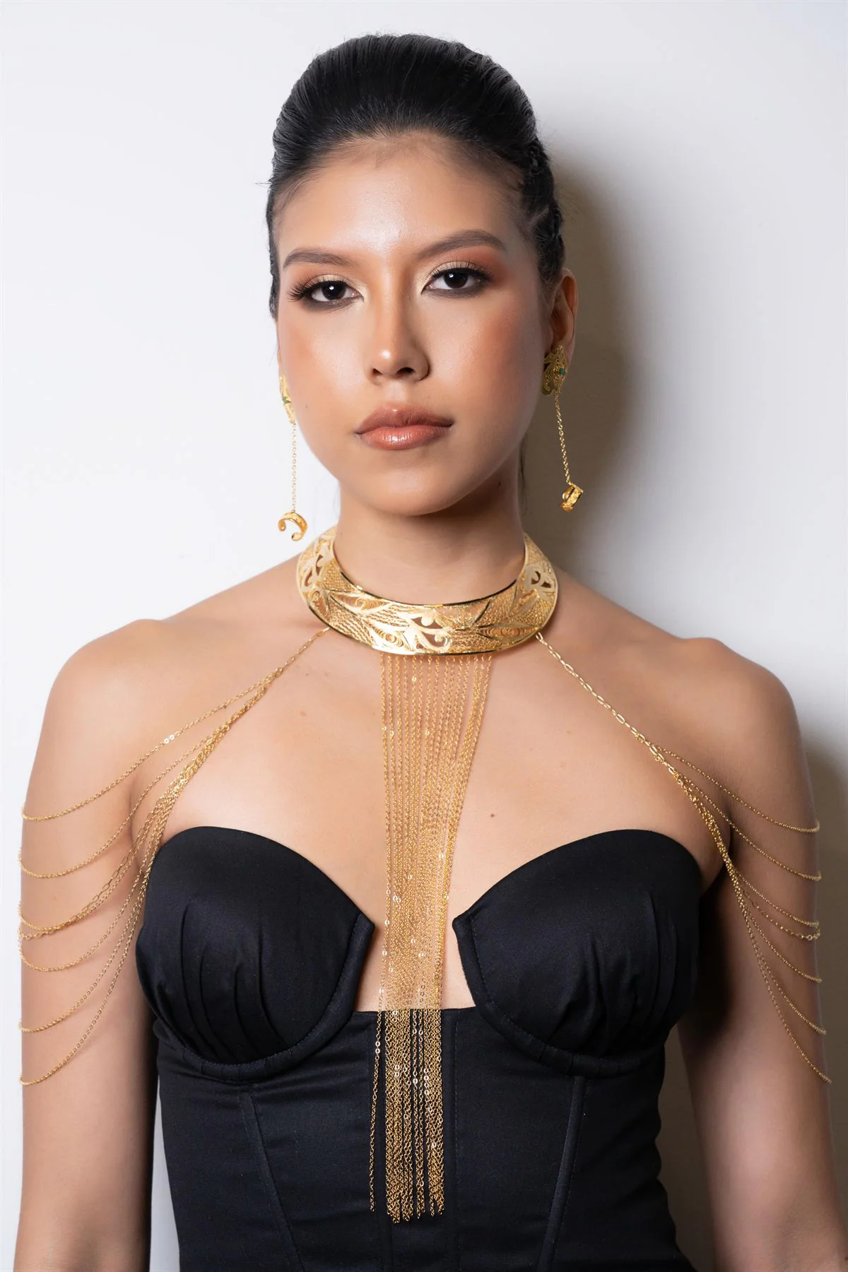 Modelo con collar de filigrana dorada y aretes a juego