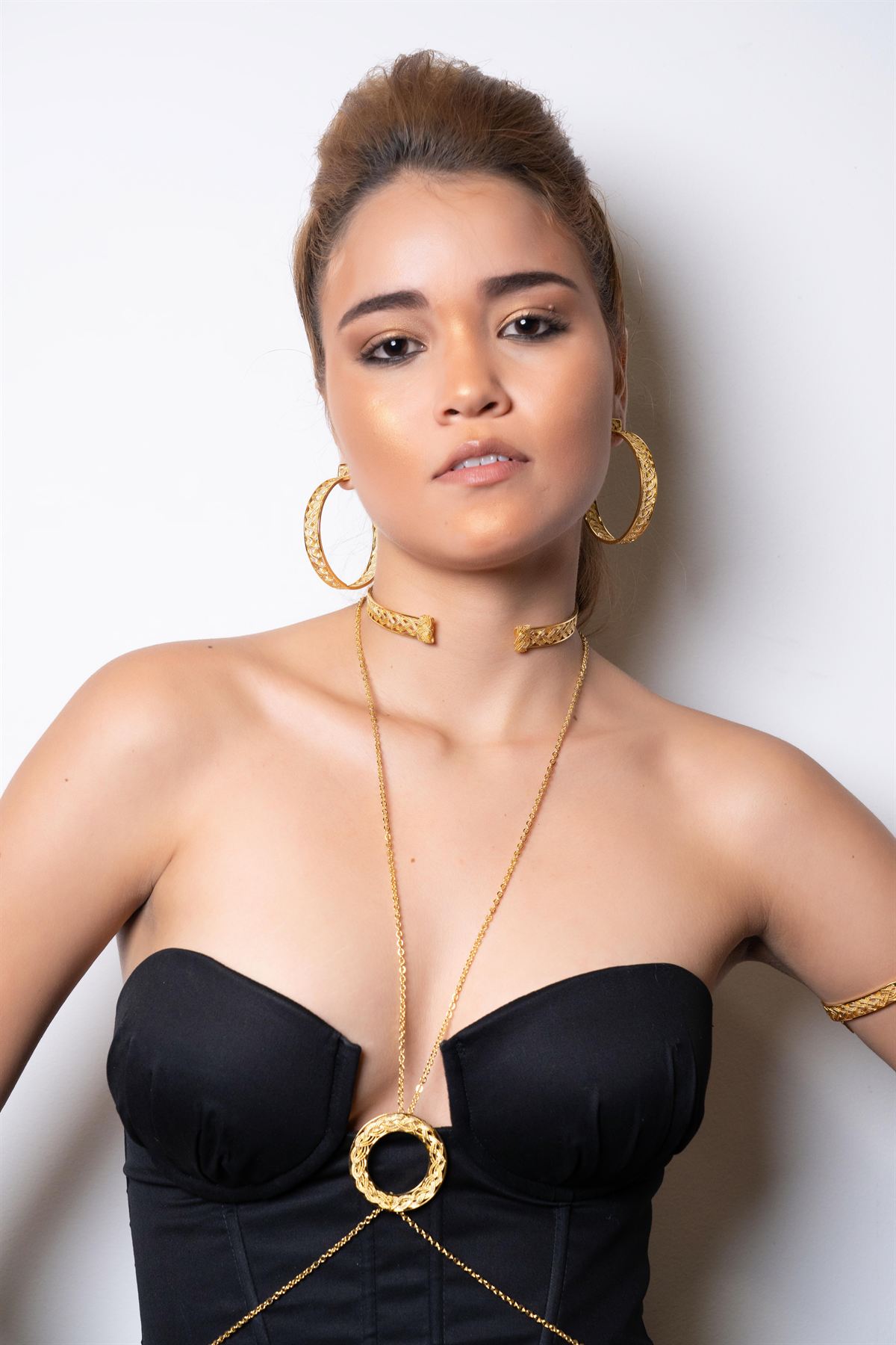 Modelo con pectoral dorado y pantalón negro de sastre