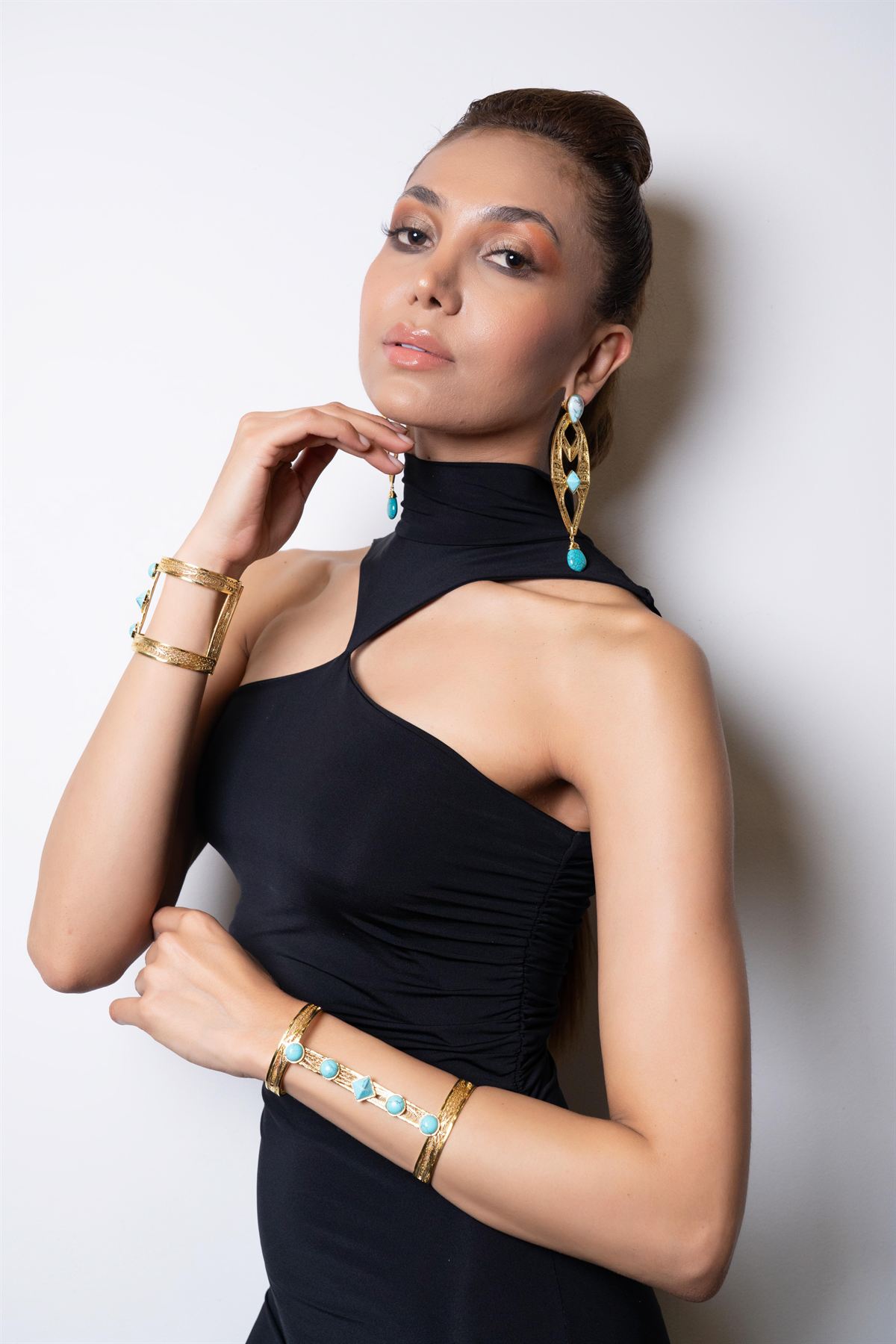 Modelo con aretes de aro y orfebrería dorada al cuello