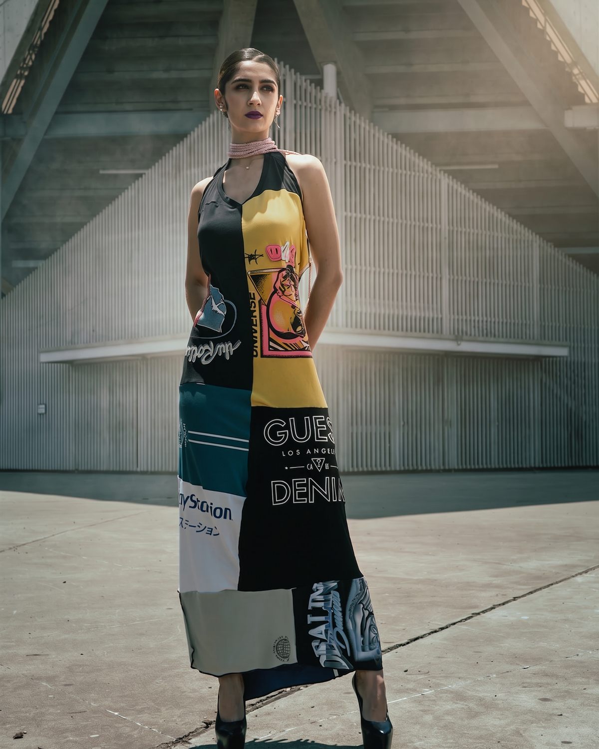 Modelo con vestido estampado frente a una estructura de hormigón