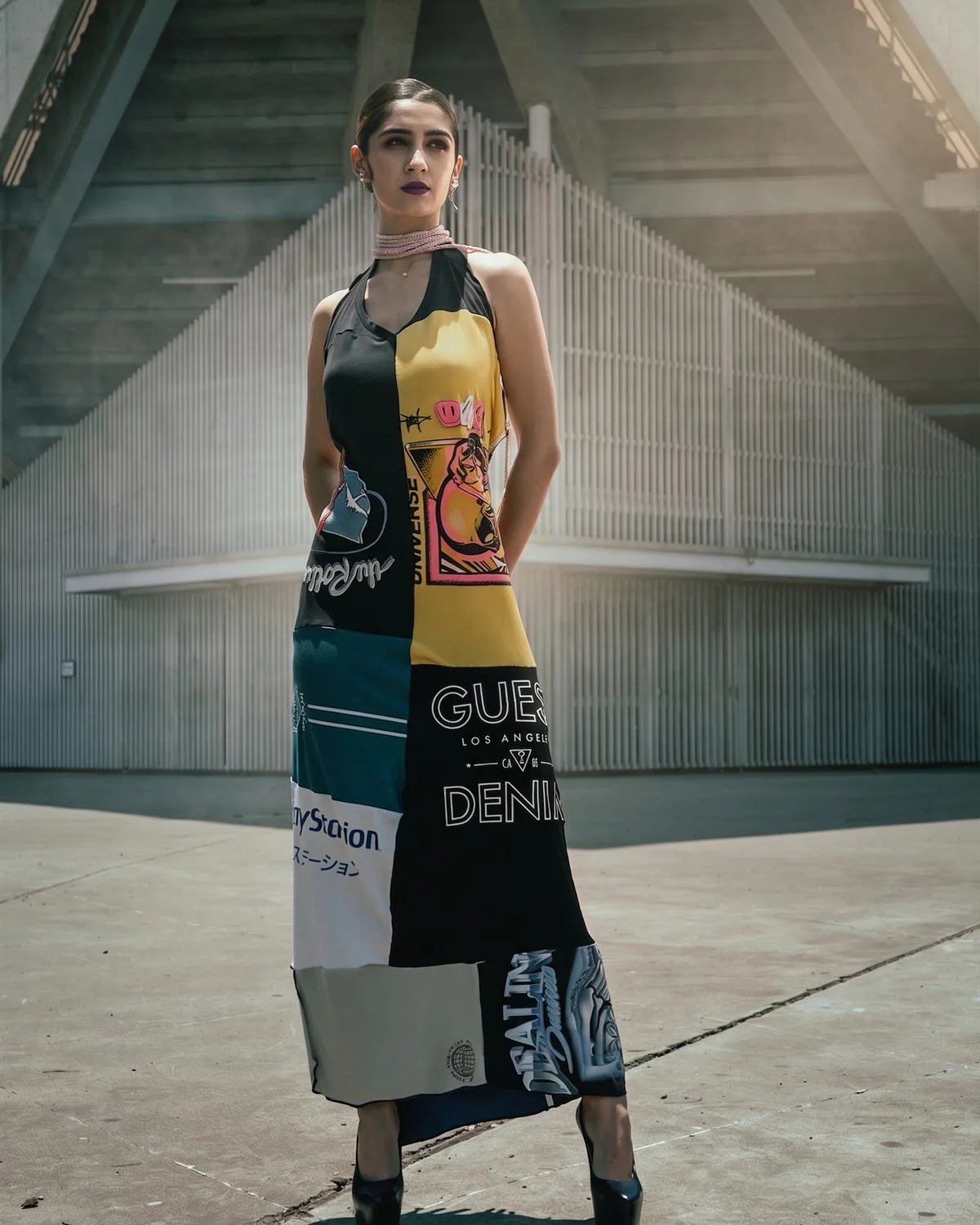 Modelo con vestido estampado frente a una estructura de hormigón