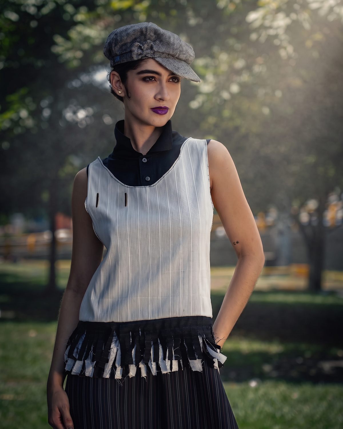 Modelo con boina y prenda de flecos en entorno urbano
