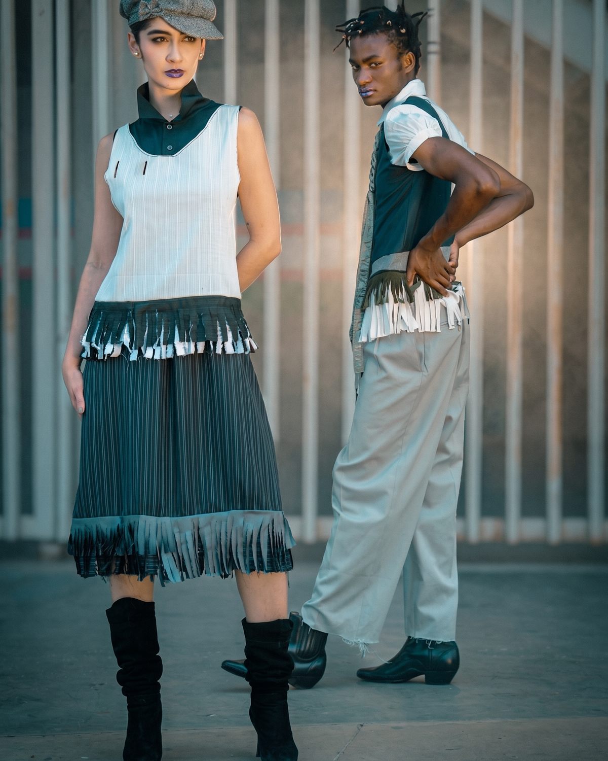 Dos modelos con prendas de la colección frente a una reja