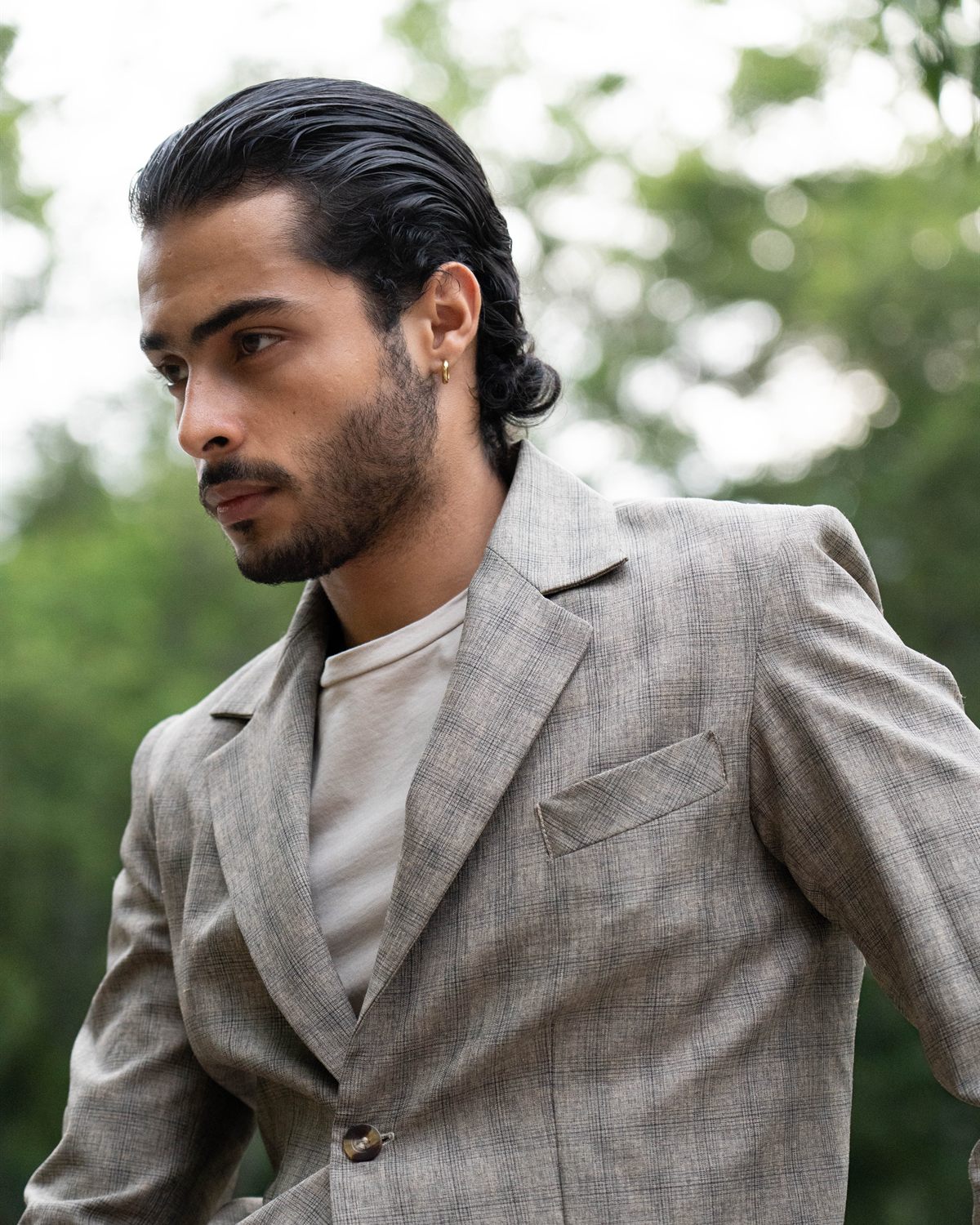 Retrato de perfil con traje gris de cuadros y gafas de sol