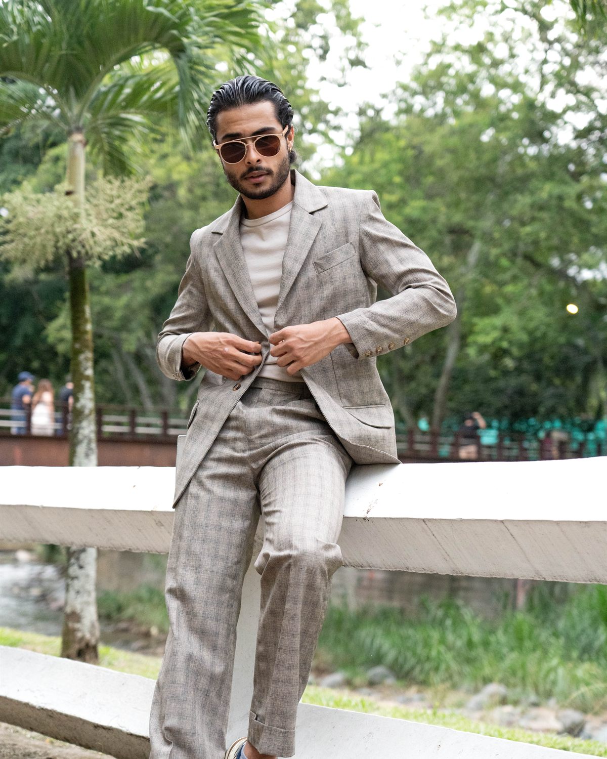 Modelo caminando con traje gris y zapatillas deportivas
