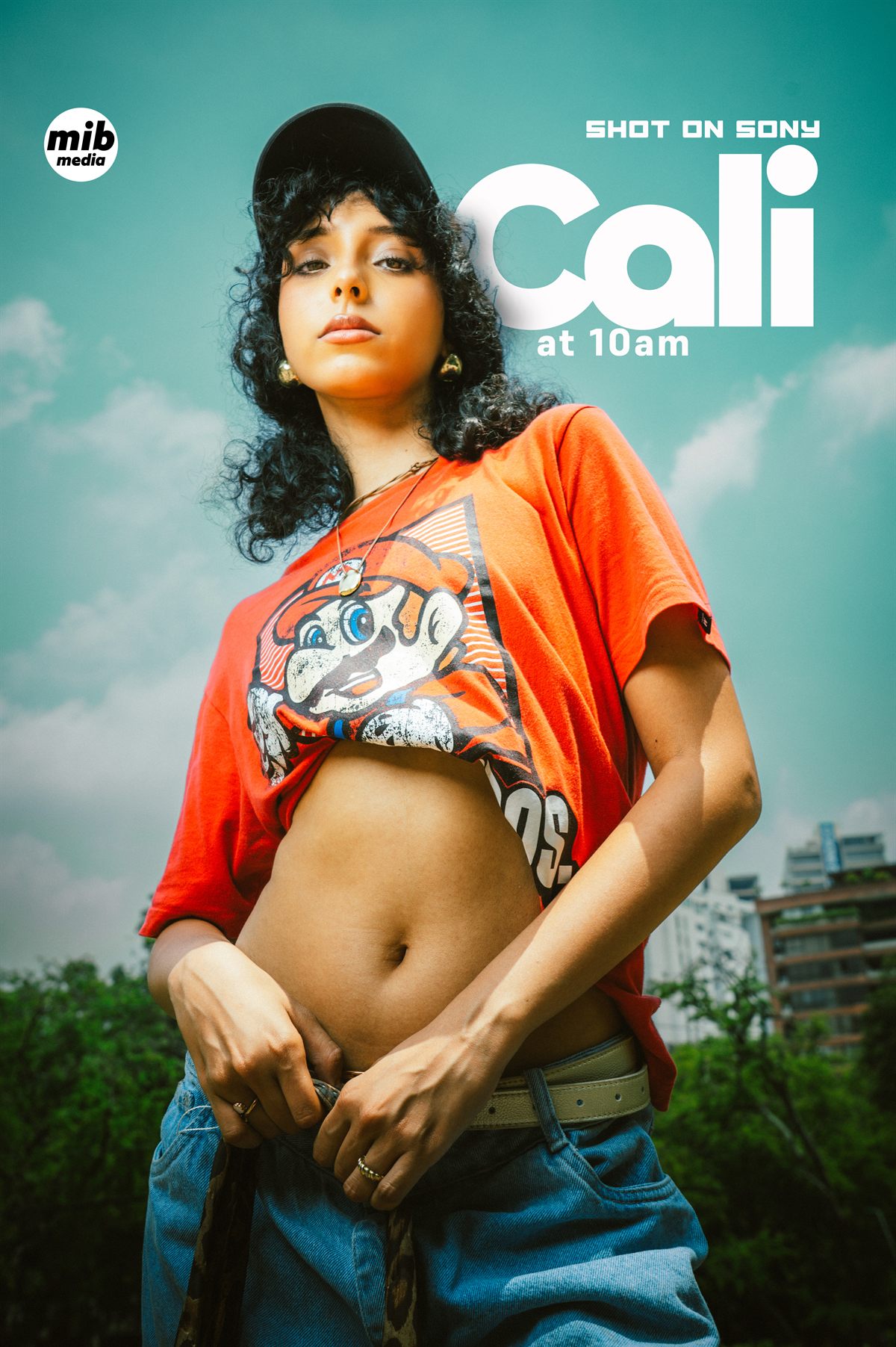 Retrato en contrapicado de una mujer con gorra y camiseta naranja sobre cielo nublado
