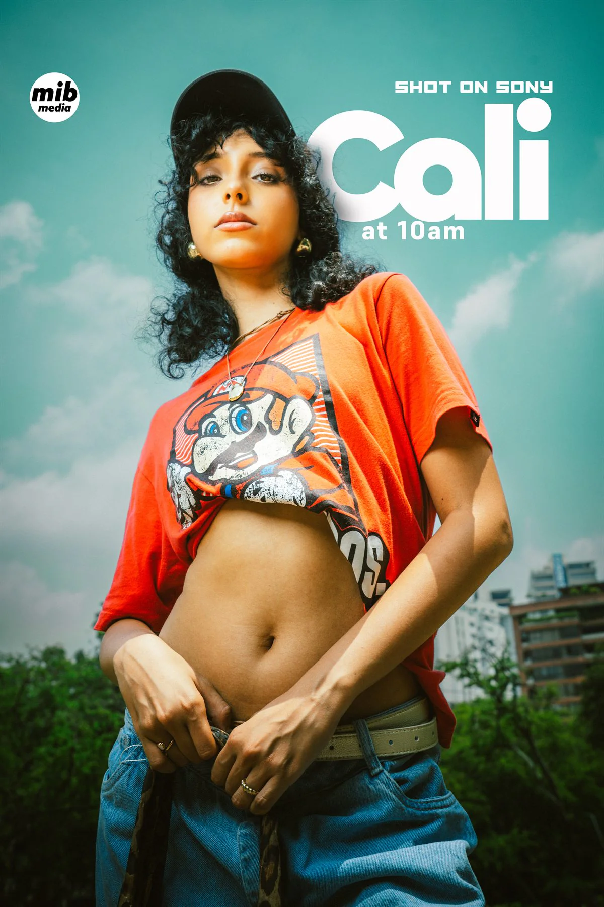Retrato en contrapicado de una mujer con gorra y camiseta naranja sobre cielo nublado